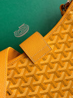 Close-up of monogram fabric with leather tab and strap attachment detail