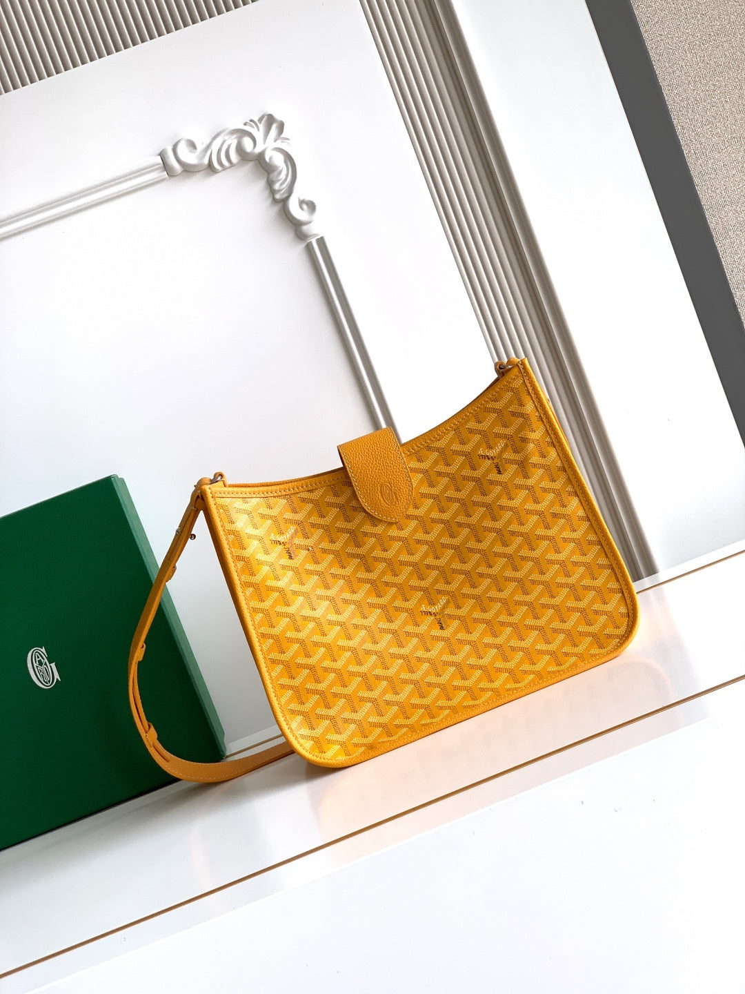 Mustard yellow structured shoulder bag with embossed monogram pattern and leather trim