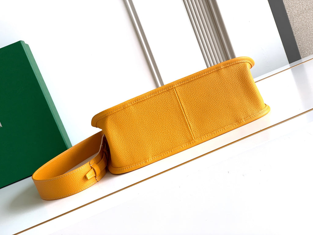 Mustard yellow leather crossbody strap and flap section of monogram bag