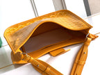 Mustard yellow monogram bag open to reveal interior lining and leather strap