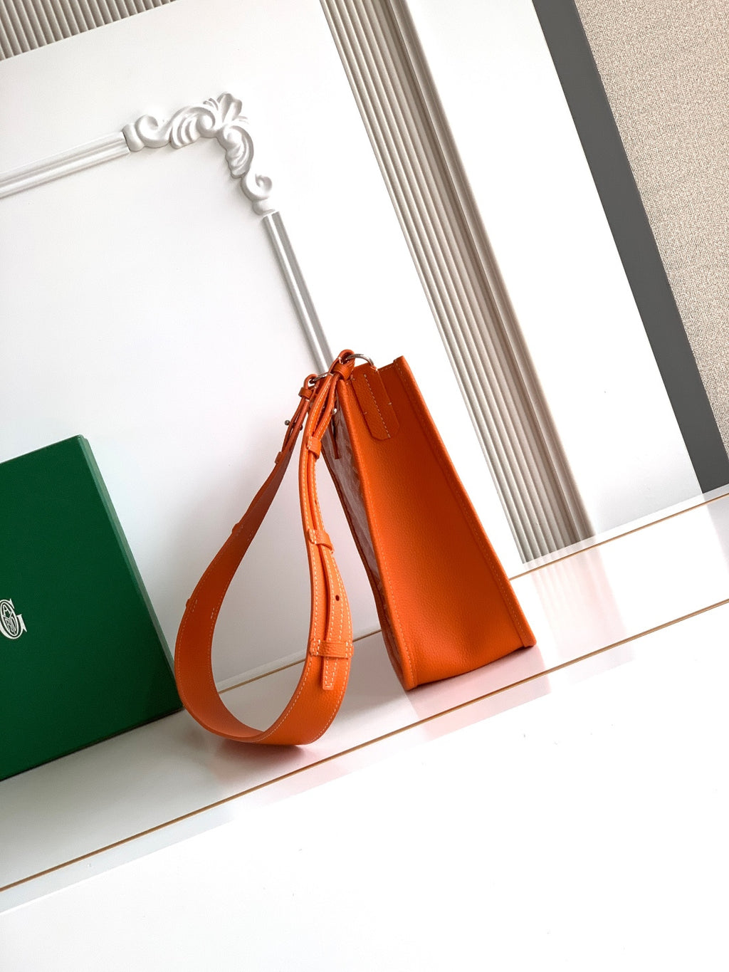 Orange bucket-style monogram bag with drawstring top and shoulder strap