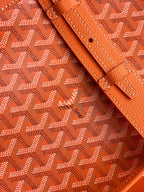 Orange monogram canvas bag with stitched leather trim and perforated tab