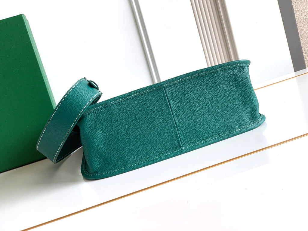 Teal leather clutch bag with top handle and short shoulder strap