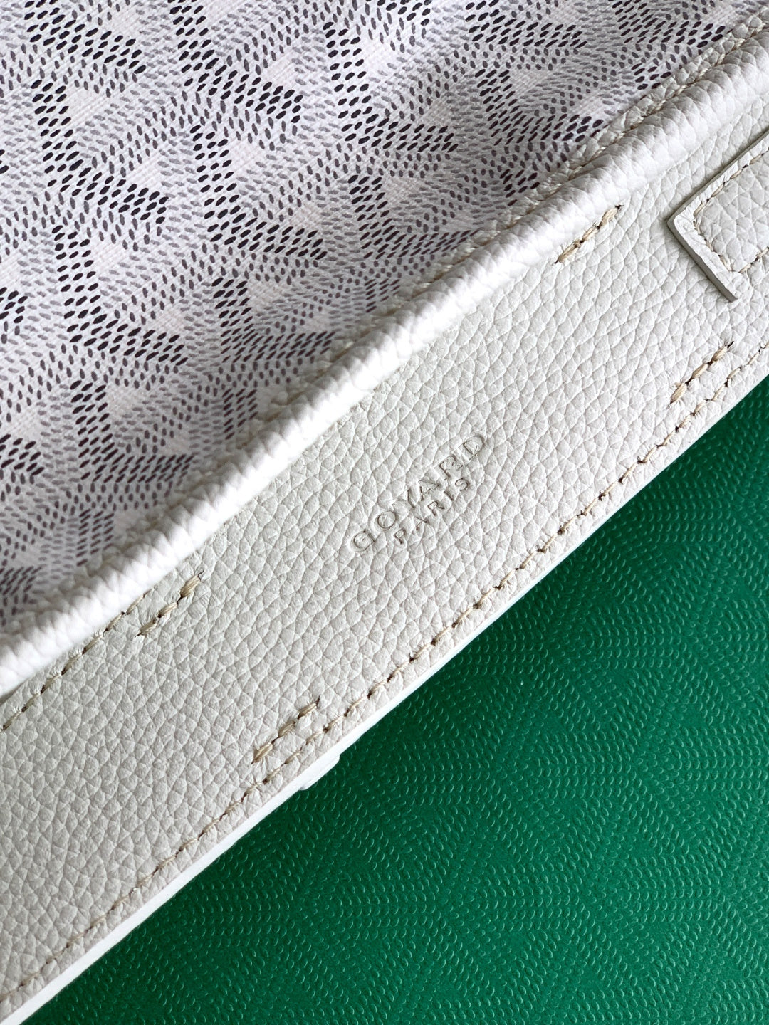 White Goyard tote bag strap seam and textured leather side panel close-up