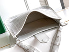 Open top of a white Goyard tote bag showing interior and side pocket