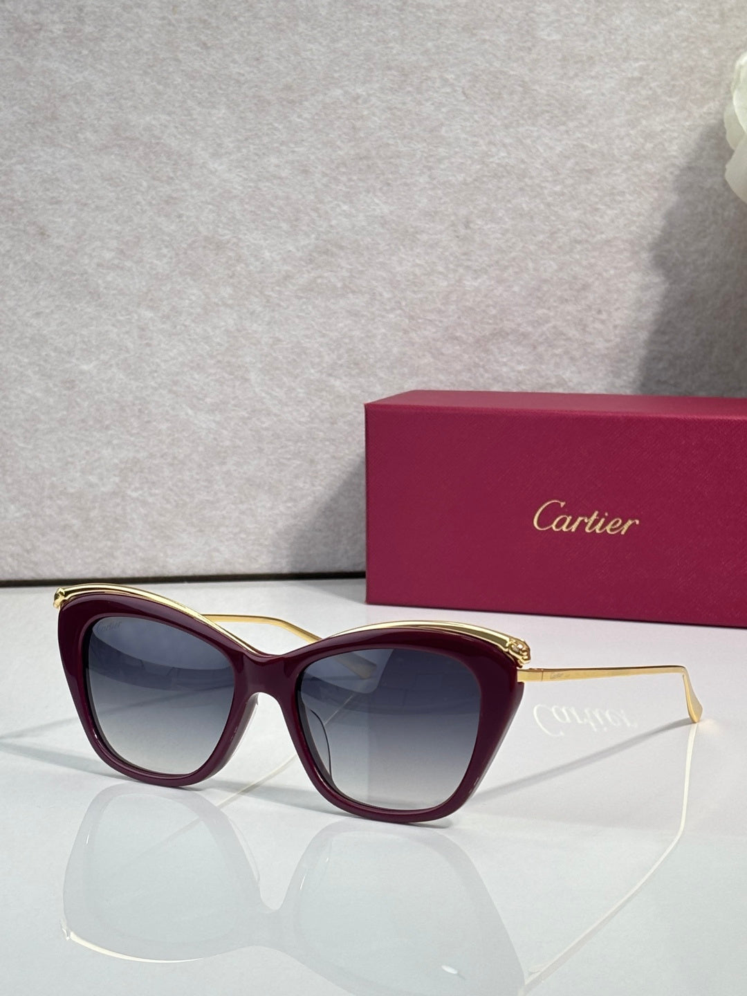 Cartier sunglasses with burgundy-accented frame and dark lenses