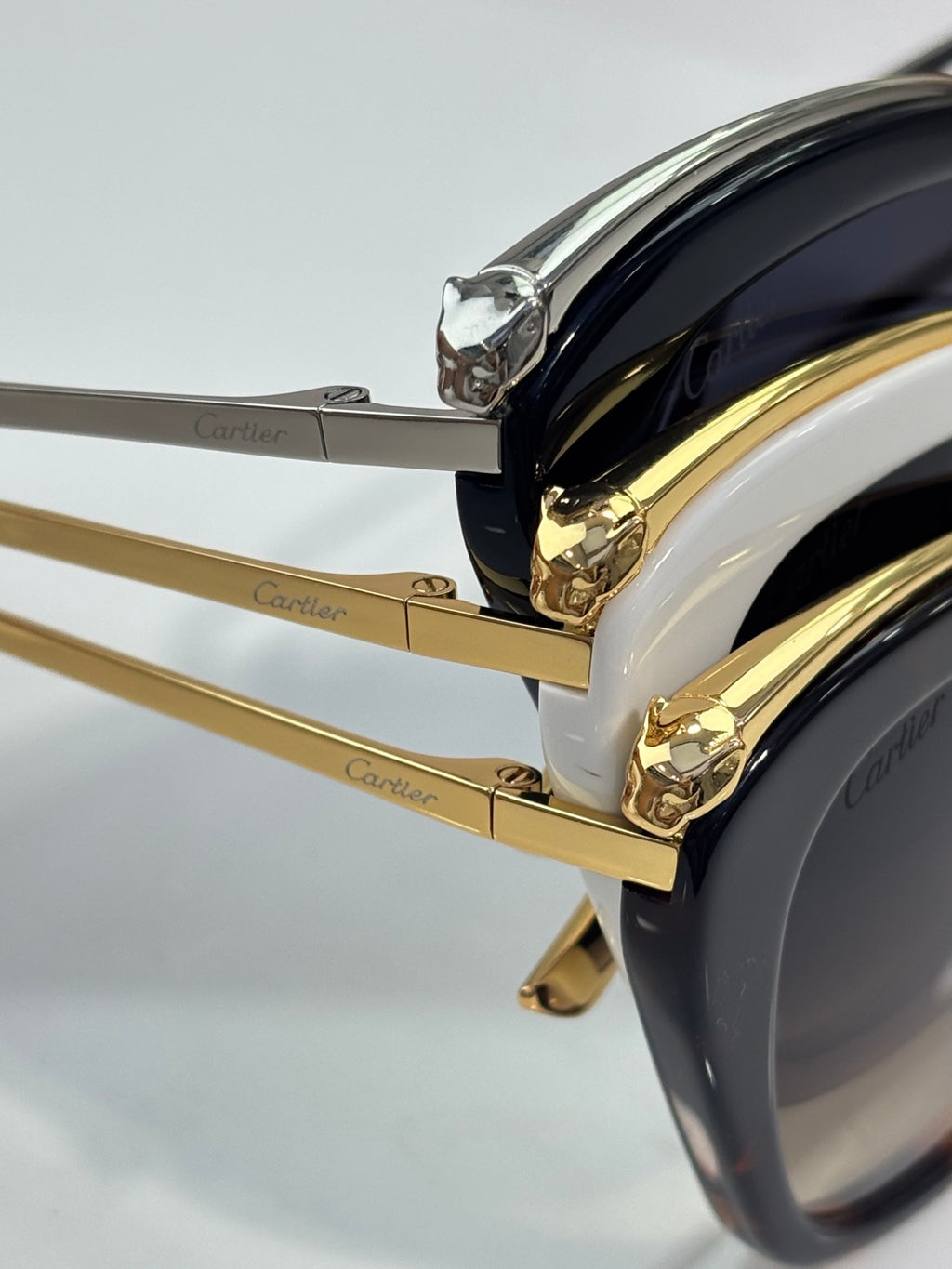 Cartier sunglasses close-up: gold temples and dark lens edge with logo detail