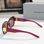 Burgundy sunglasses side view with gold bar hinges and square tinted lenses.