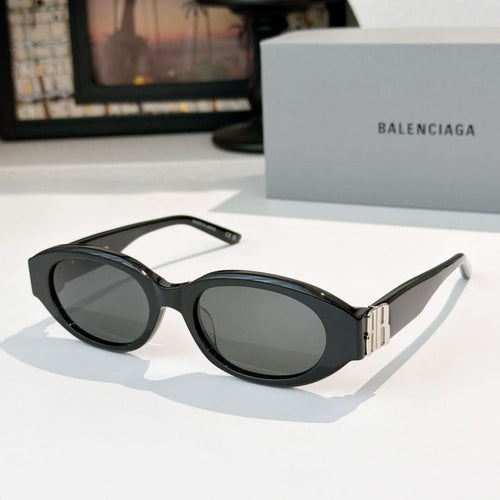 Black cat-eye sunglasses with dark lenses and gold bridge detail