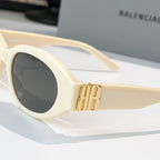Cream cat-eye sunglasses with dark lenses and gold logo bridge detail