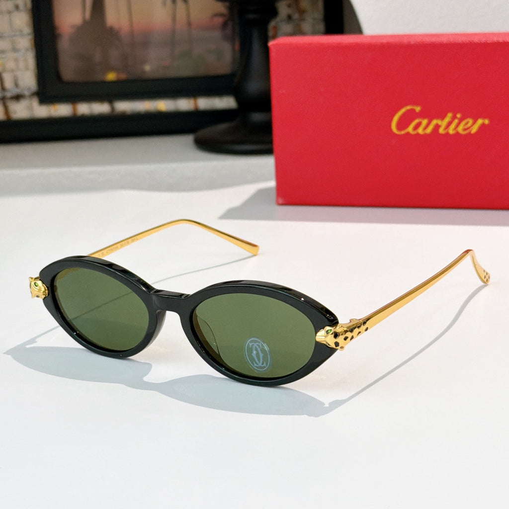 Black eyeglasses with gold temples and green-tinted lenses, round-to-cat-eye style.