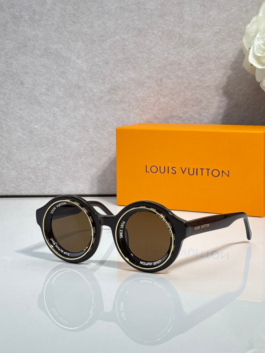 Louis Vuitton sunglasses, dark round frames with amber-tinted lenses