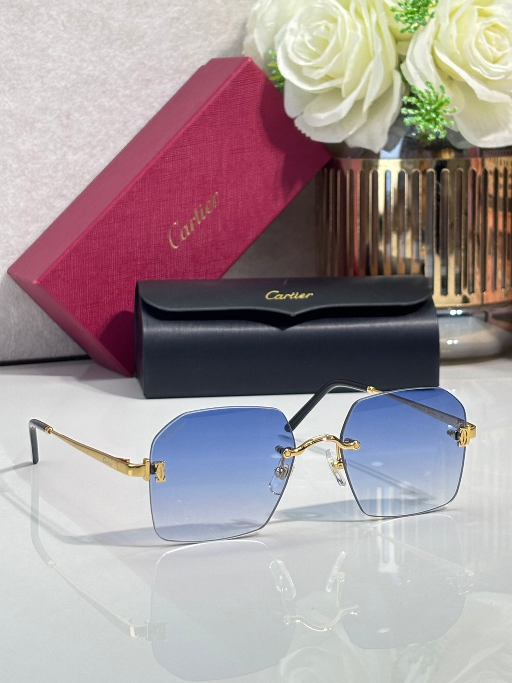 Cartier glasses with blue-tinted lenses, black frame, and gold-tone hardware