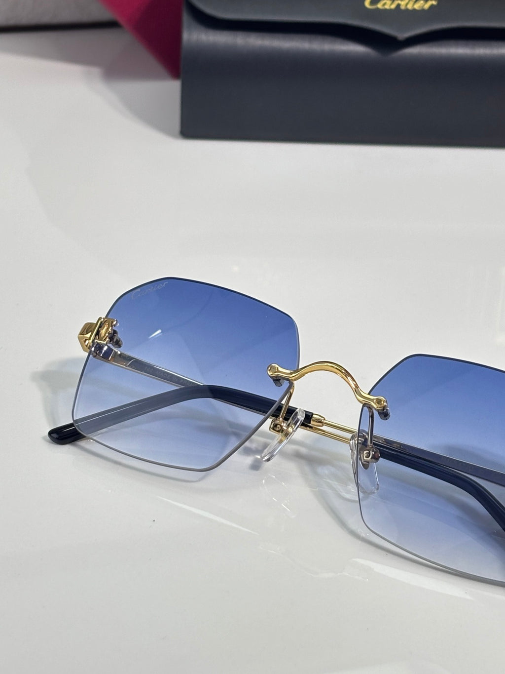 Cartier glasses with blue-tinted lenses, black frame, and gold-tone metal details