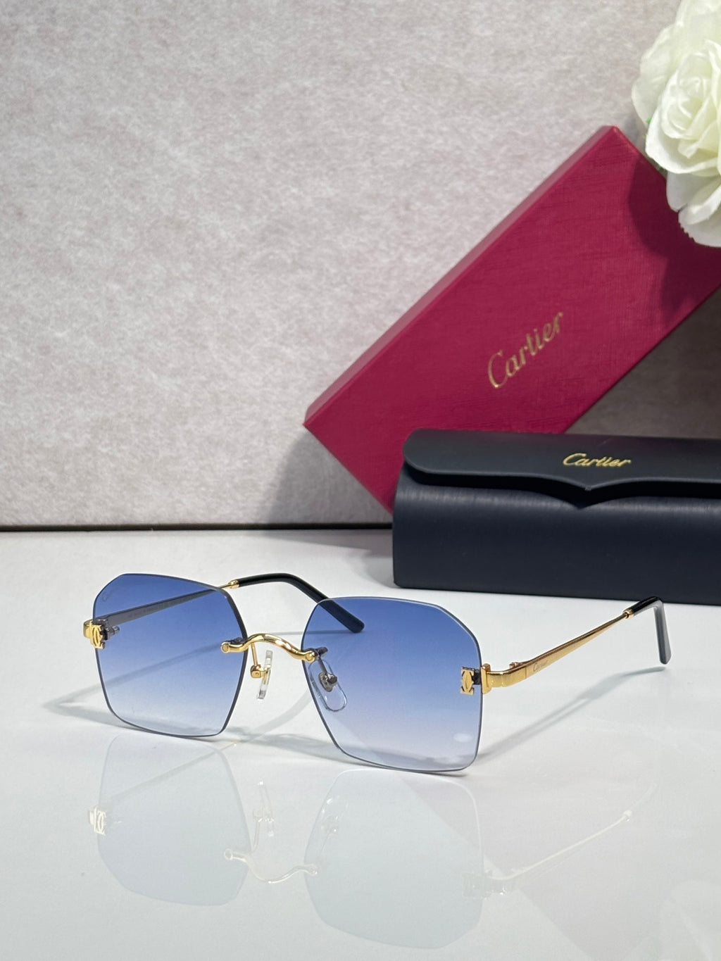 Cartier glasses with blue-tinted lenses, black frame, and gold-tone temples