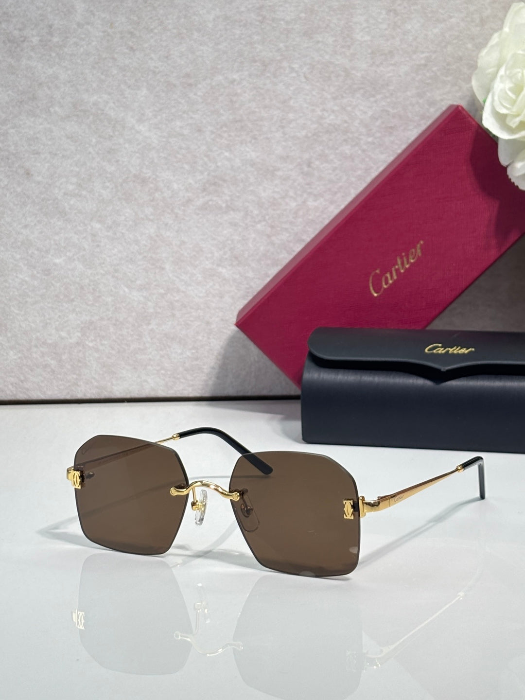Cartier glasses with brown-tinted lenses, black frame, and gold-tone temples