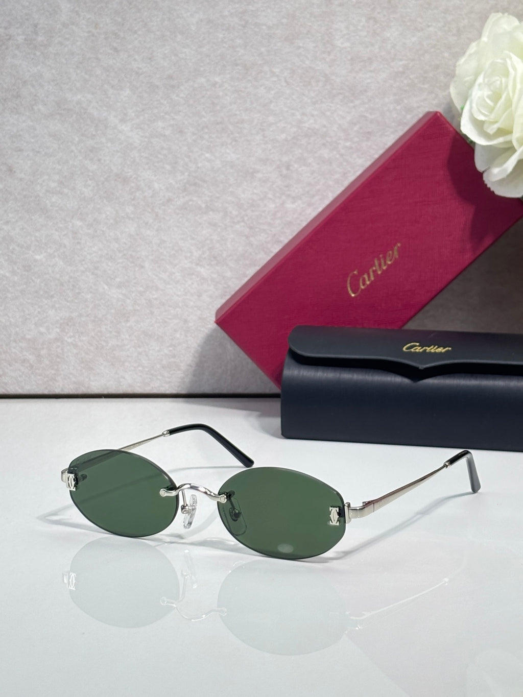 Round sunglasses with gold frame, dark temples, and green tinted lenses