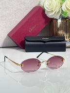 Round sunglasses with gold frame, dark temples, and pink tinted lenses