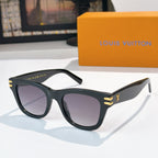 Cat-eye sunglasses with dark frames, tinted lenses, and gold LV logo on temples.