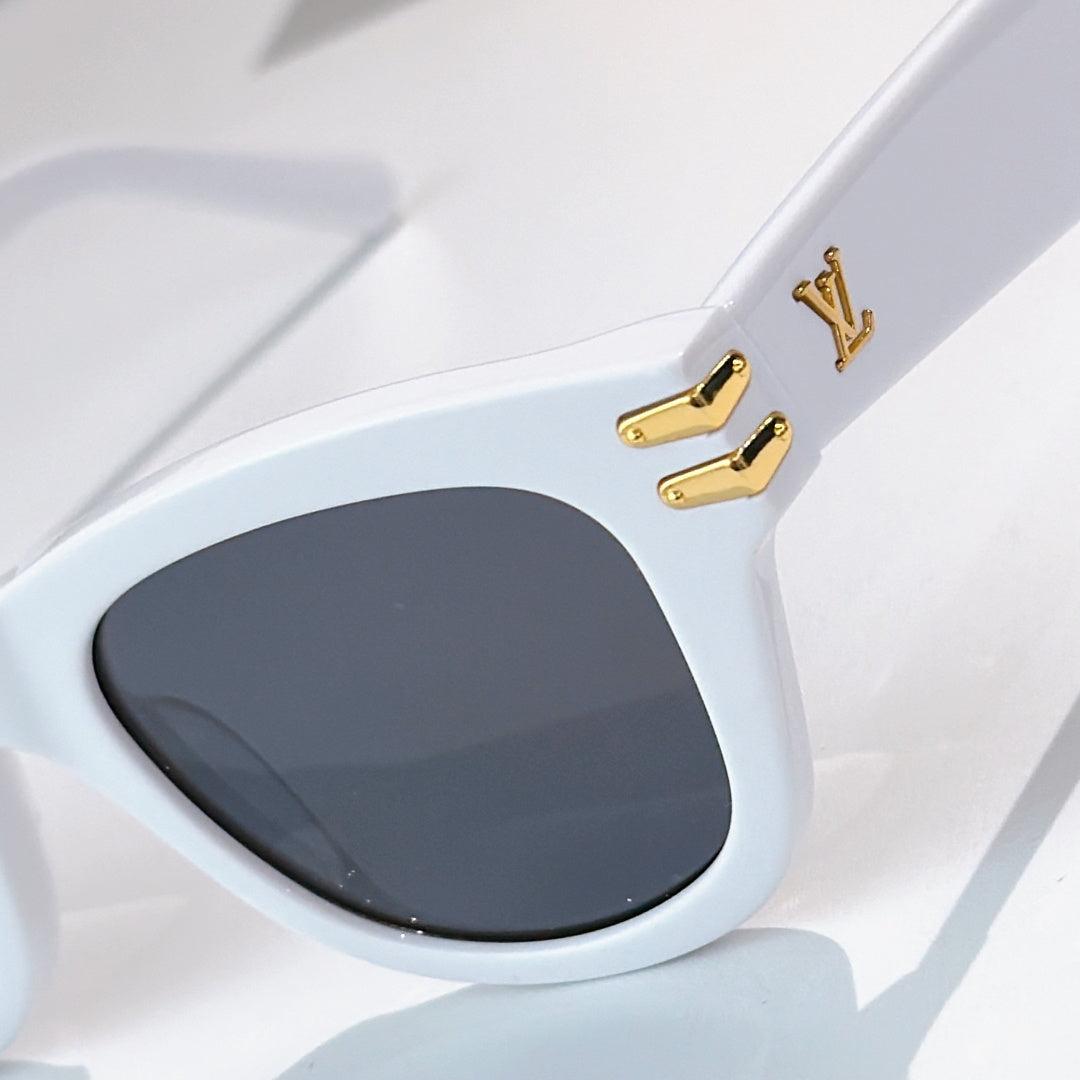 White cat-eye sunglasses with dark tinted lens and gold LV hardware on the temple.