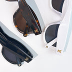 Dark cat-eye sunglasses with tinted lenses and gold LV emblems on the temples.