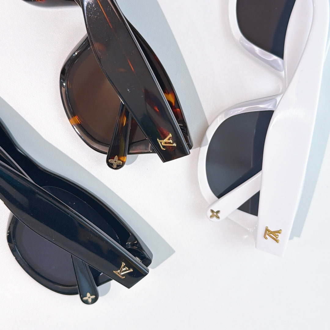 Dark cat-eye sunglasses with tinted lenses and gold LV emblems on the temples.