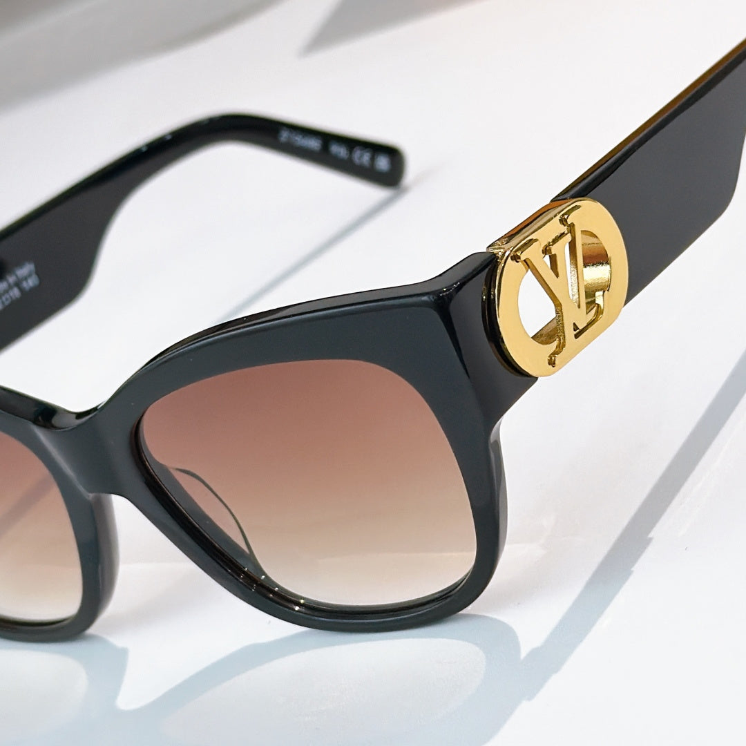 Black cat-eye sunglasses close-up with gold LV logo detail and tinted lenses