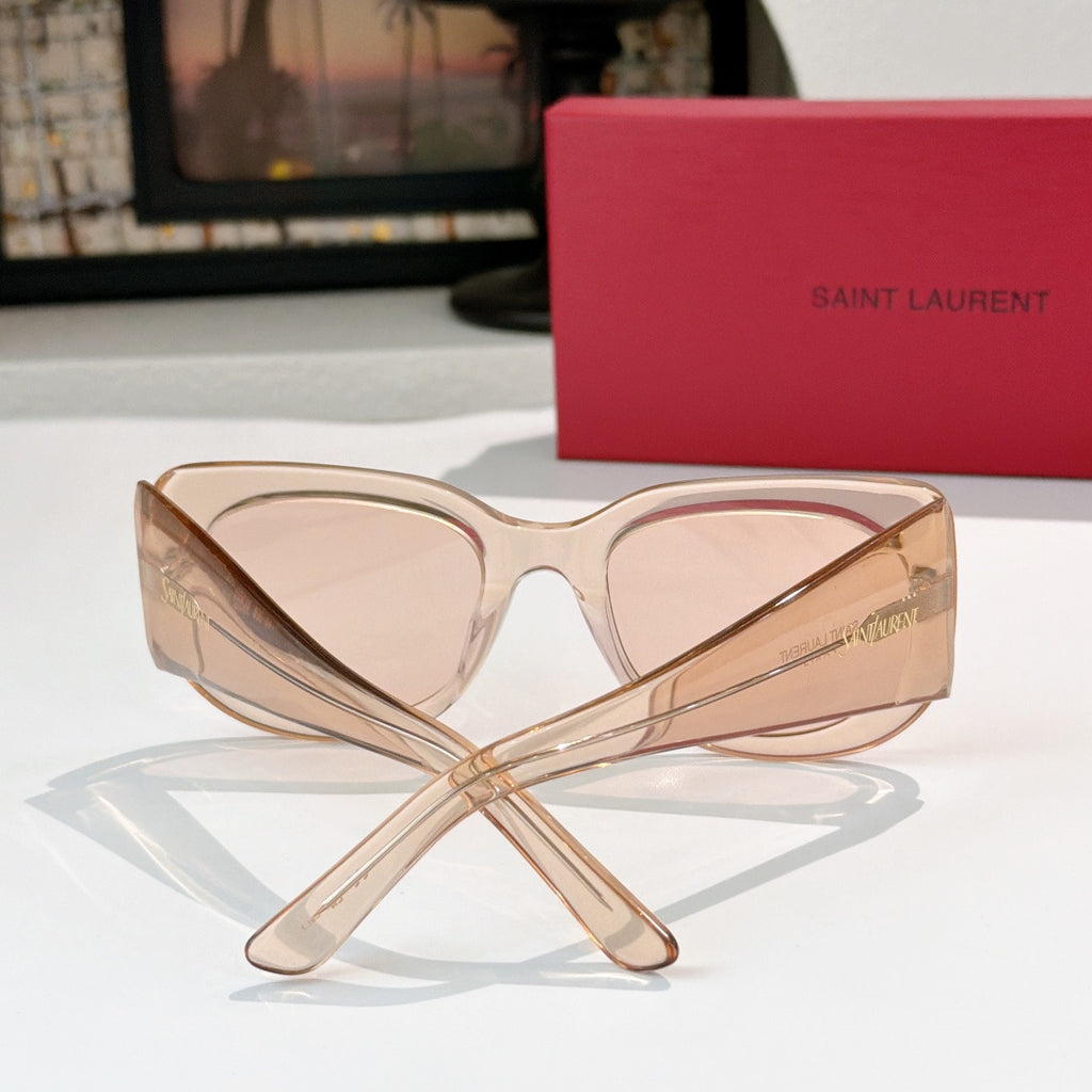 Sunglasses with translucent peach frames and light rose lenses, cat-eye shape.