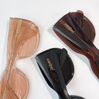 Stacked sunglasses: translucent beige pair and dark brown pair with black lenses.