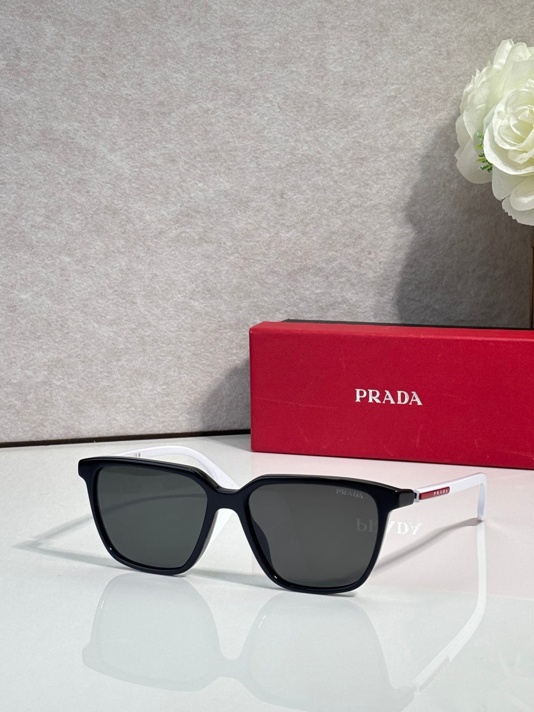 Prada sunglasses with black-and-white color-block frames and dark lenses.