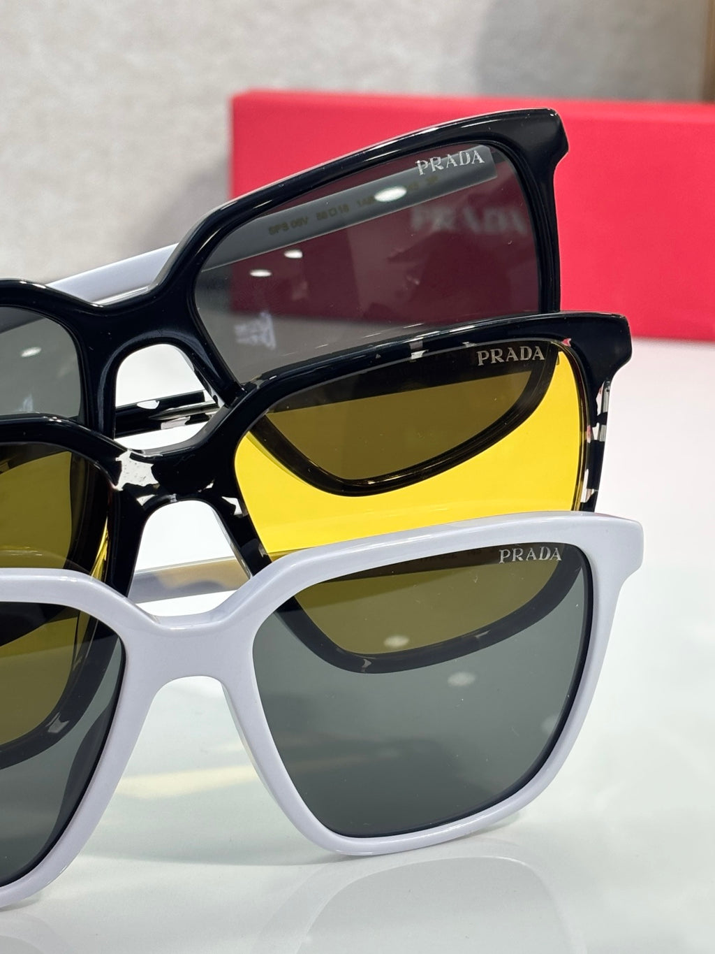 Prada sunglasses with black and white frames, featuring yellow-tinted lenses.