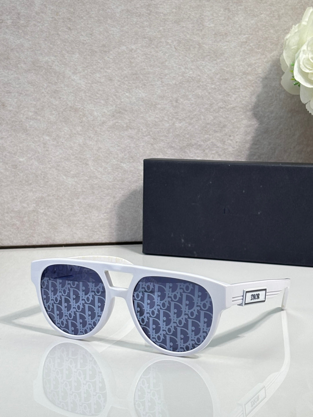 Dior sunglasses with white frames and blue patterned lenses