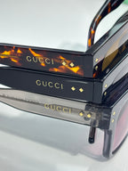 Gucci sunglasses close-up showing temple arms and gold stud details on black frame