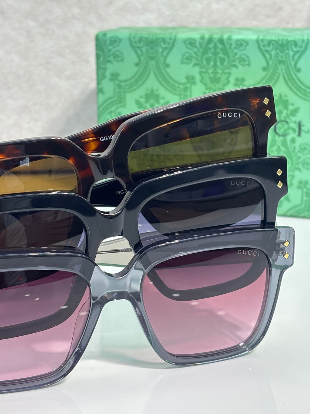 Gucci square sunglasses stack with tortoiseshell and blue-tinted frames, pink lenses visible