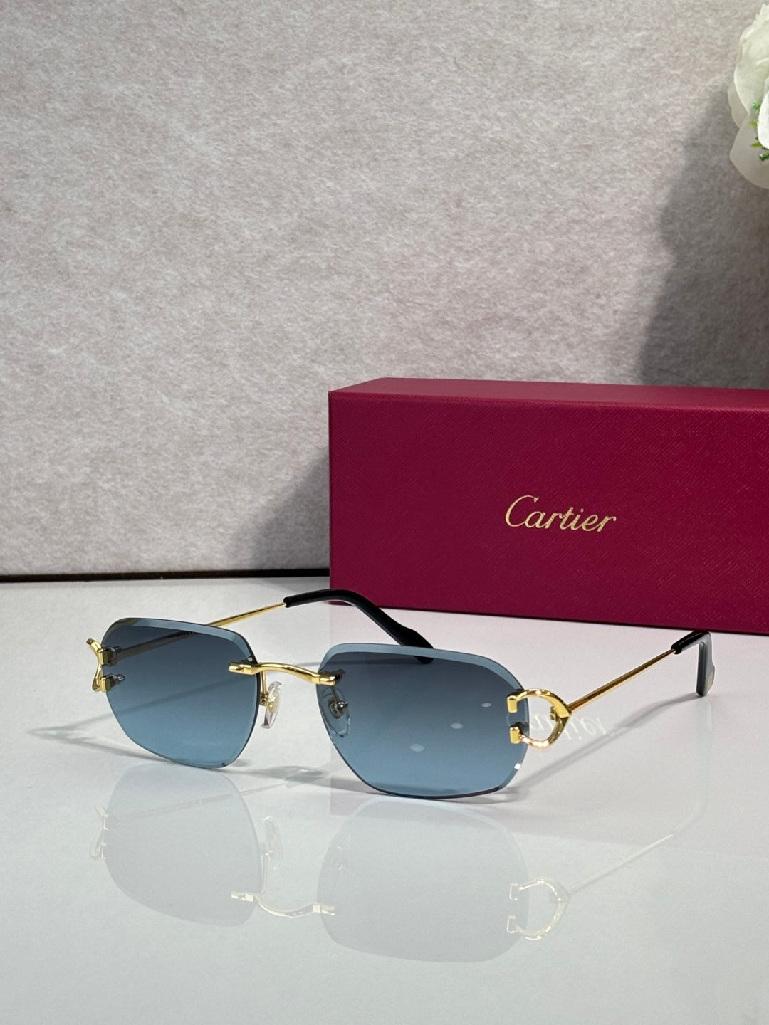 Cartier round-frame sunglasses with light blue lenses and gold metal accents