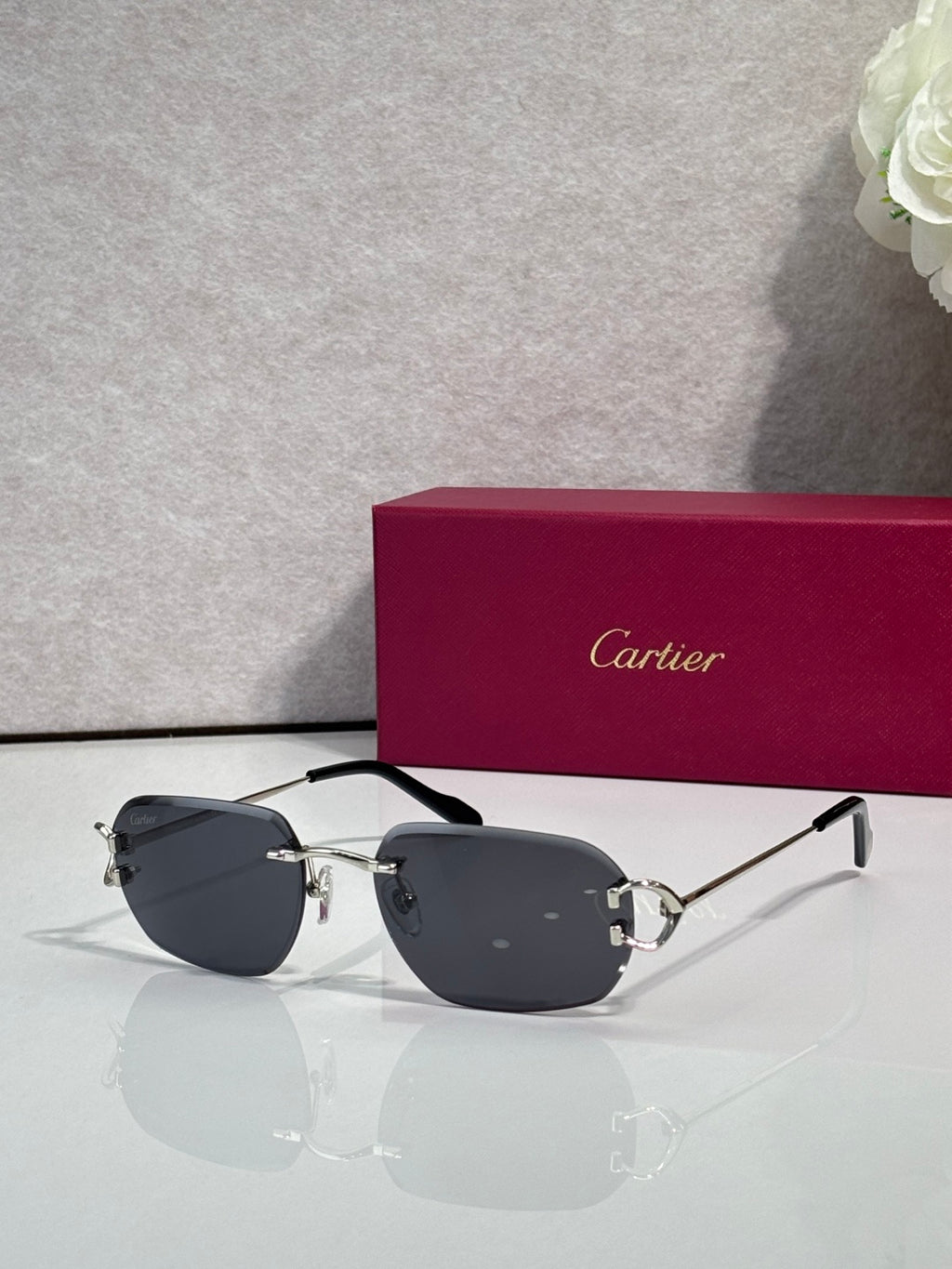 Cartier round-frame sunglasses with dark lenses and silver metal arms