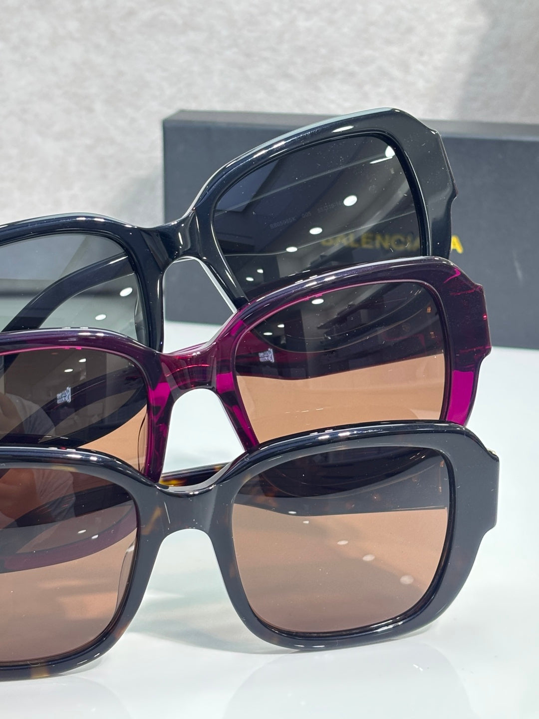 Sunglasses side view with gold logo hinges on navy and purple frames