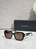 Black square sunglasses with brown-tinted lenses and gold logo temple detail