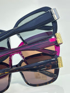 Sunglasses side view with gold logo hinges on dark and purple frames
