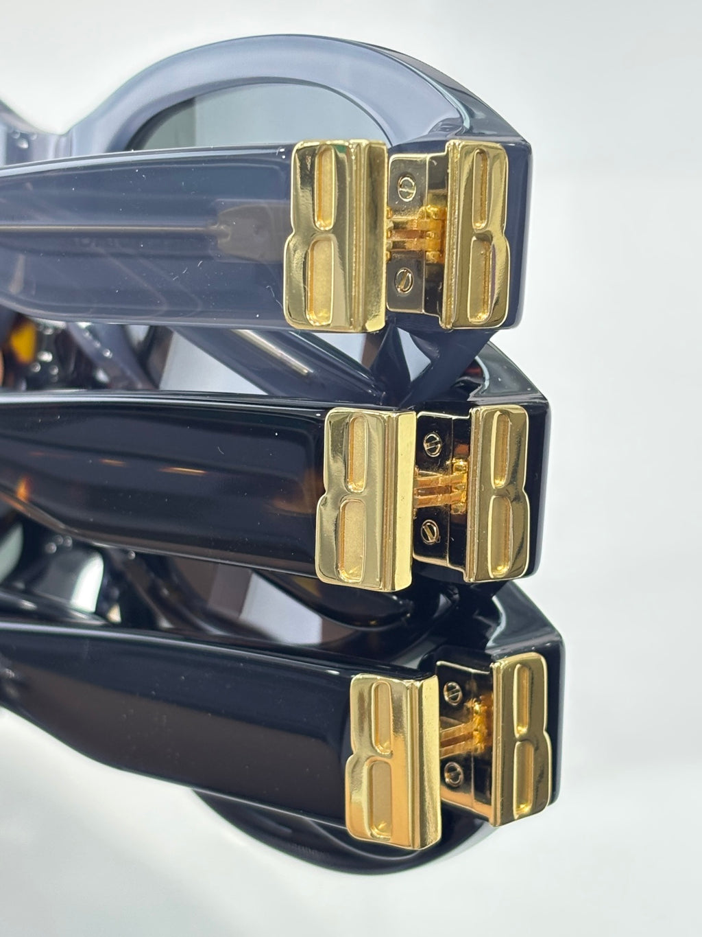 Balenciaga sunglasses close-up with blue-and-black frames and gold logo bridge
