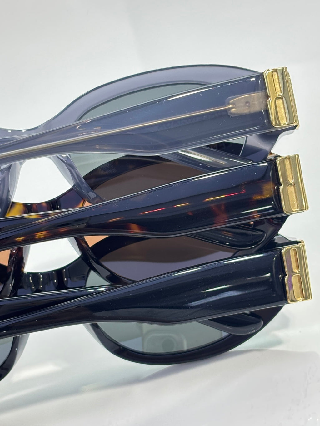 Balenciaga sunglasses side view with translucent blue frame and gold logo detail