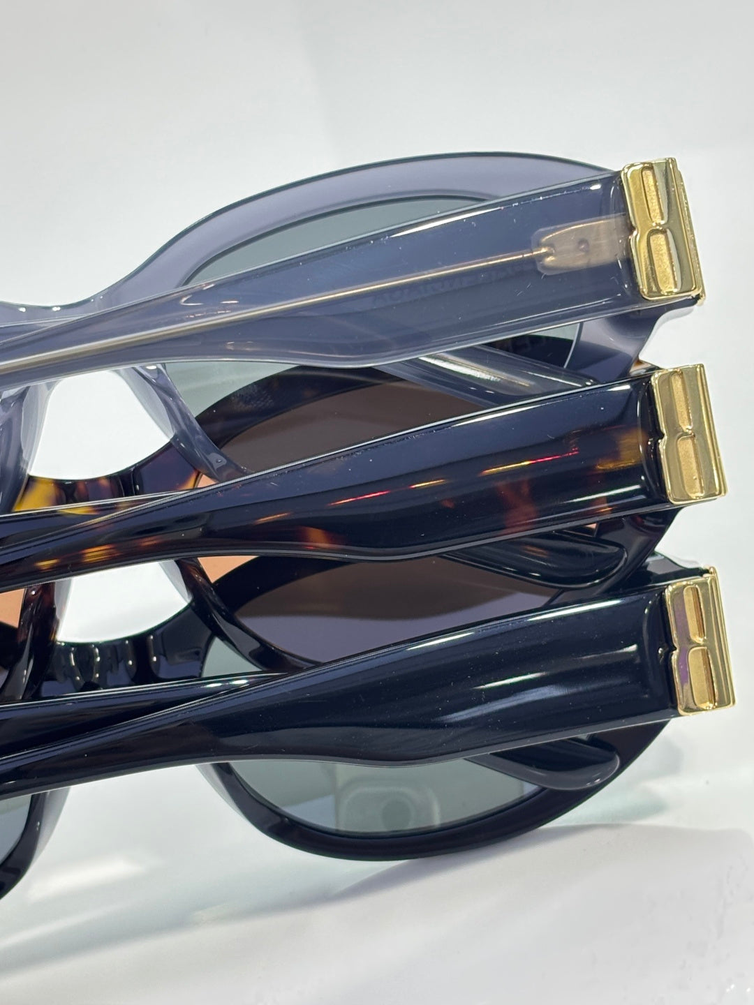 Balenciaga sunglasses side view with translucent blue frame and gold logo detail