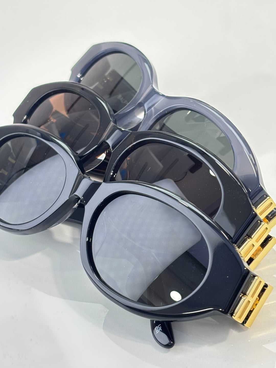 Balenciaga sunglasses set with translucent blue and dark frames, gold logo details