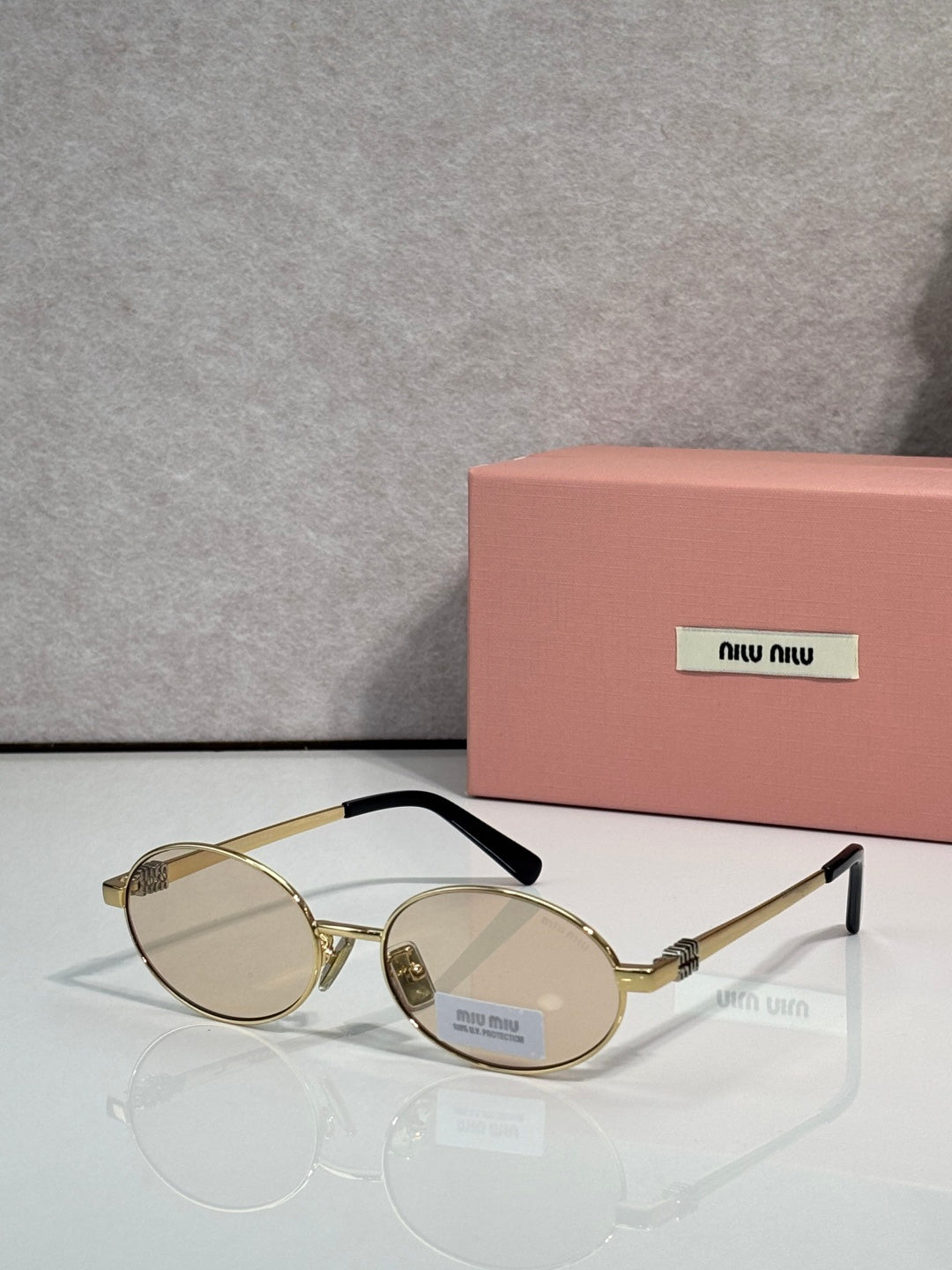MiuMiu round eyeglasses with gold frame and clear lenses, black temple detail