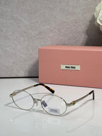 MiuMiu round eyeglasses with gold frame and clear lenses, black temple accents