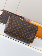 Louis Vuitton monogram canvas handbag with top zipper, tan trim, and colorful charm at handle