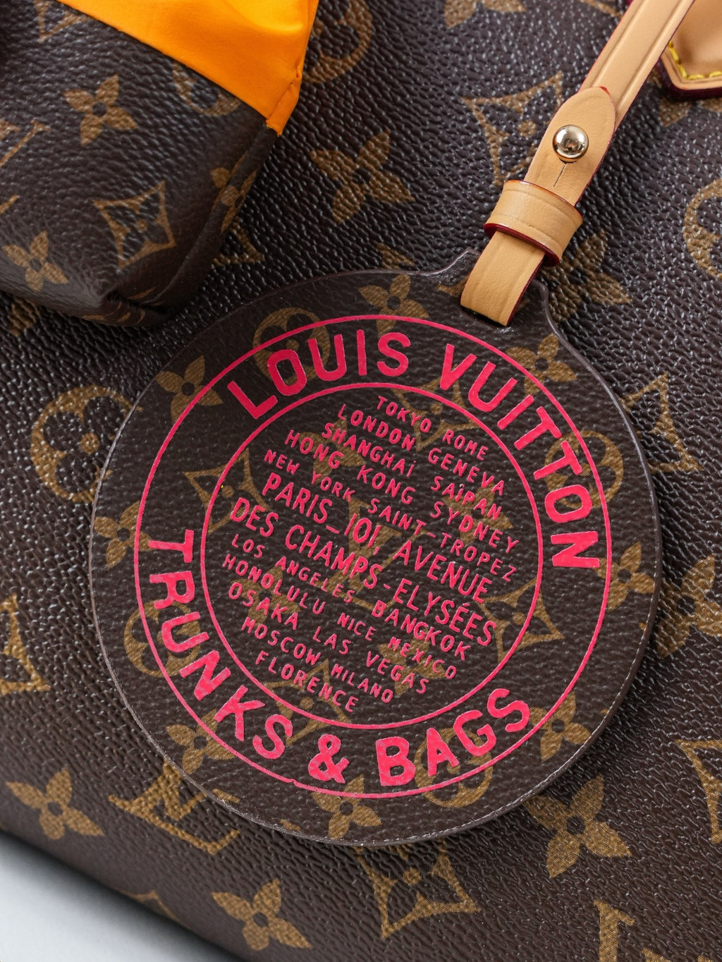 Louis Vuitton monogram canvas charm patch reading “Louis Vuitton” and “Bags & Trains”