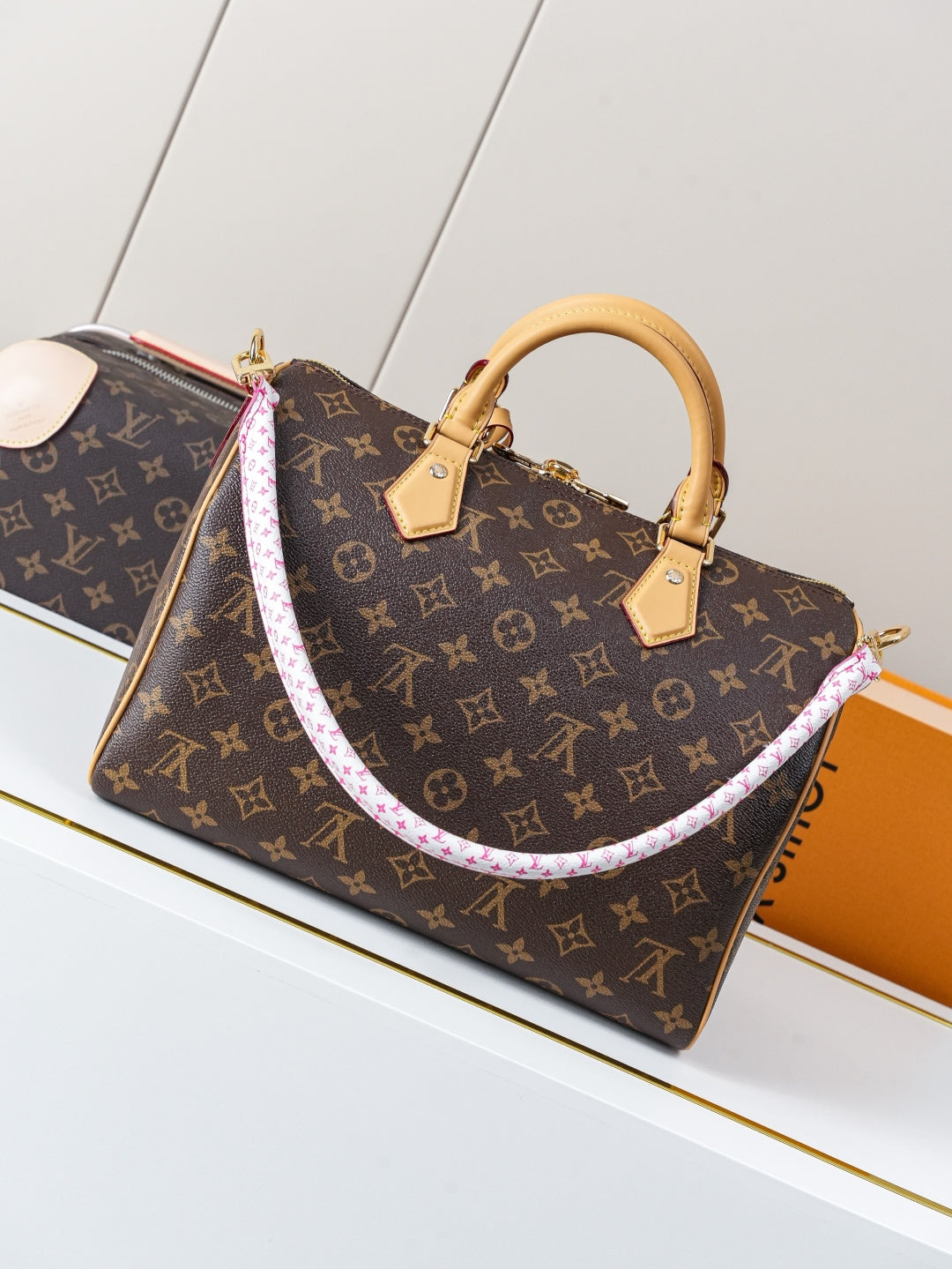 Louis Vuitton monogram canvas handbag with tan top handles and purple-trimmed shoulder strap