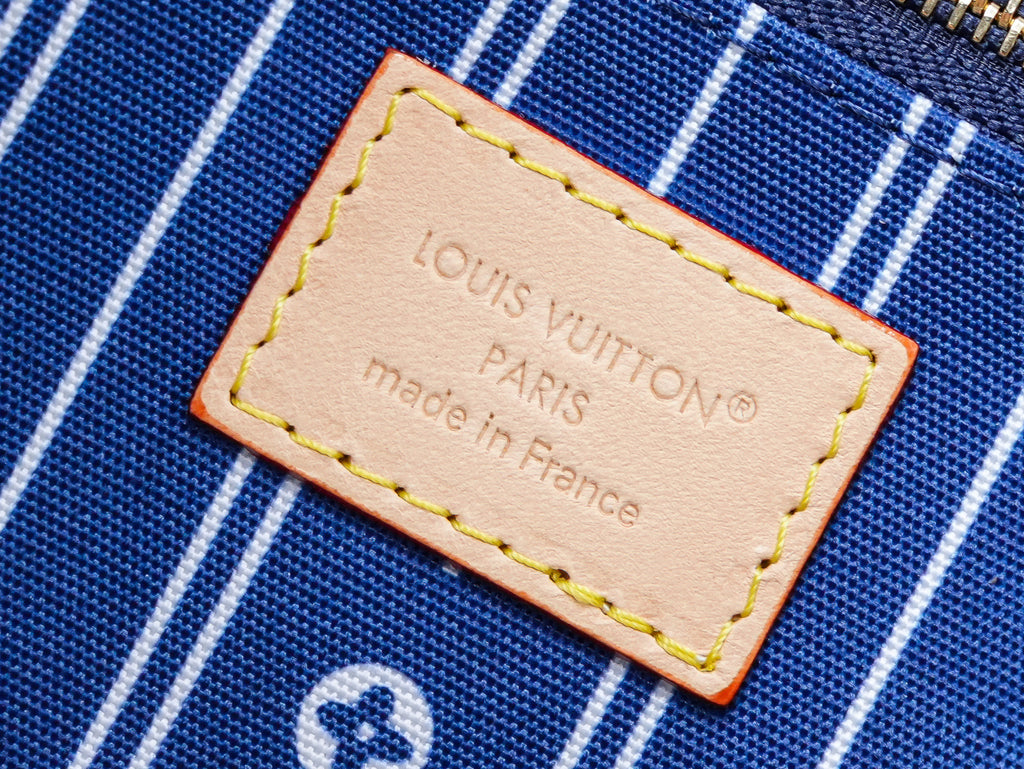 Beige brand label on blue-striped lining reading "Louis Vuitton" and "Made in France"