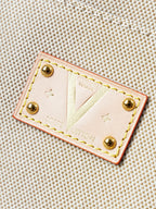 Beige leather patch with gold studs and tan stitching on canvas tote